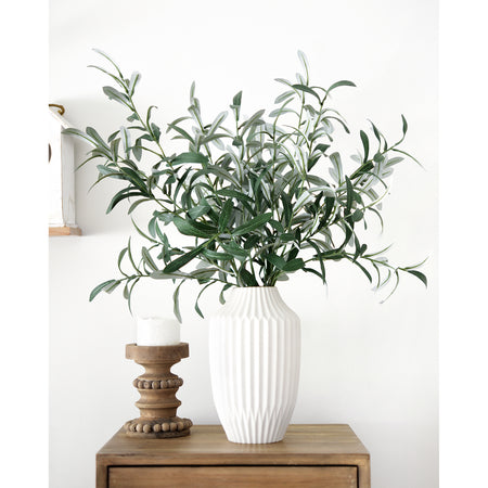 Elegant artificial olive branches displayed in a tall white ceramic vase, styled with a wooden candle holder for modern farmhouse décor