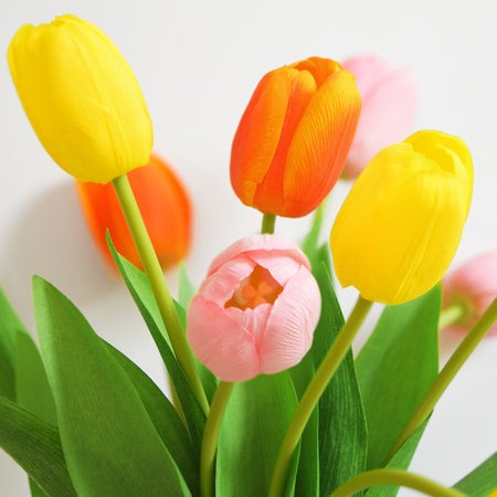 Close-up of realistic tulip blooms with soft yellow petals and natural green leaves.