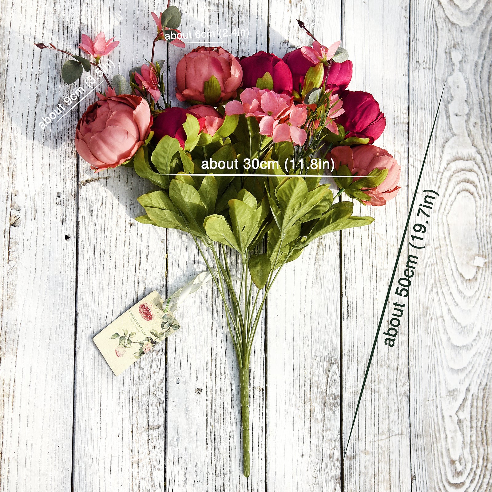 Two bundles of artificial peonies in cream, burgundy, and pink shades with hydrangea accents, shown laid out on a rustic wooden surface.