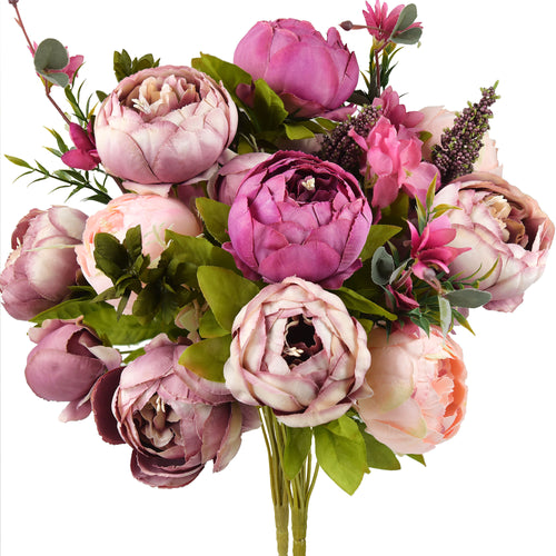 A vibrant artificial peony bouquet featuring shades of magenta, pink, and purple, with lifelike blooms and greenery, arranged in a glass vase.
