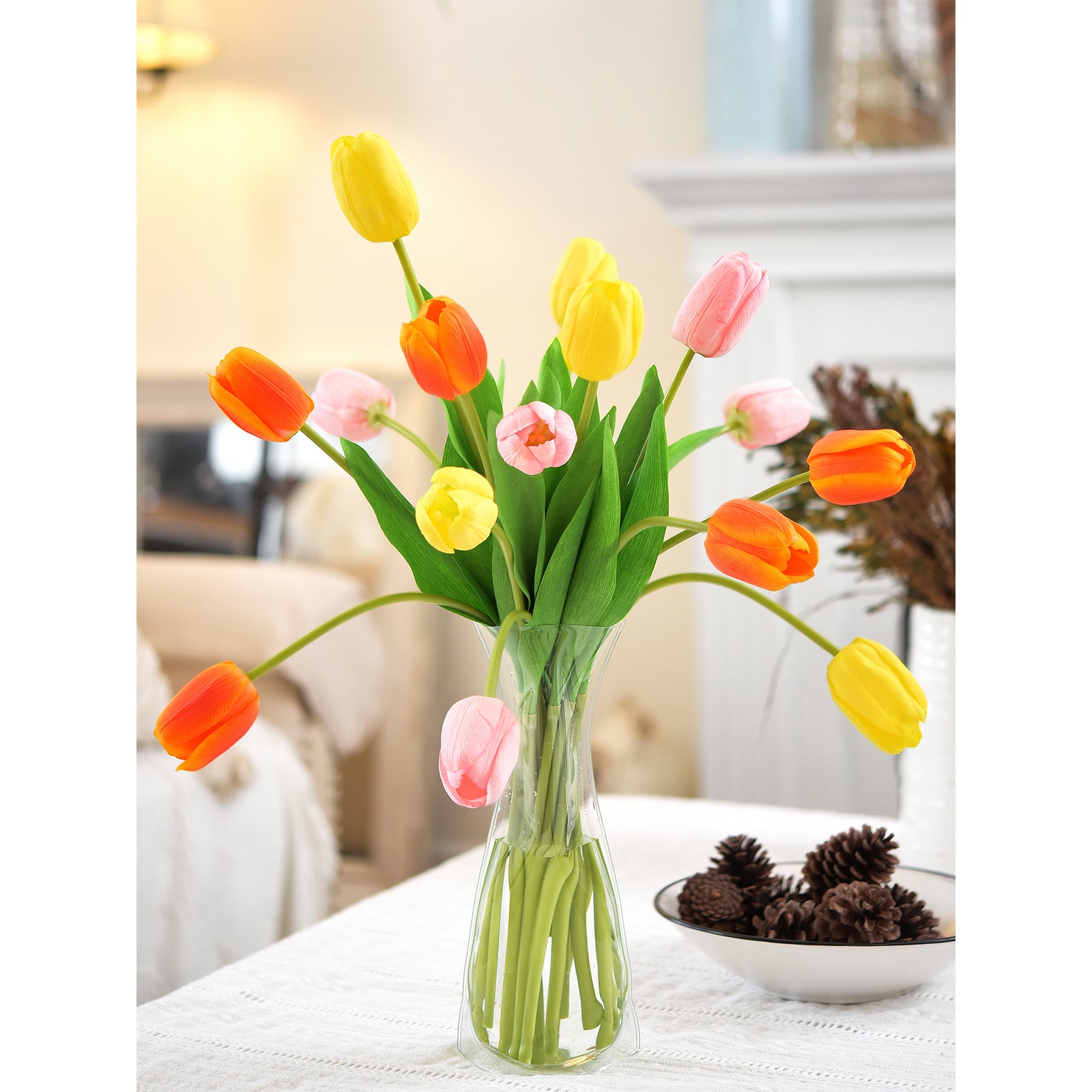 Bright tulip arrangement in a vase, placed on a warm fireplace mantel.
