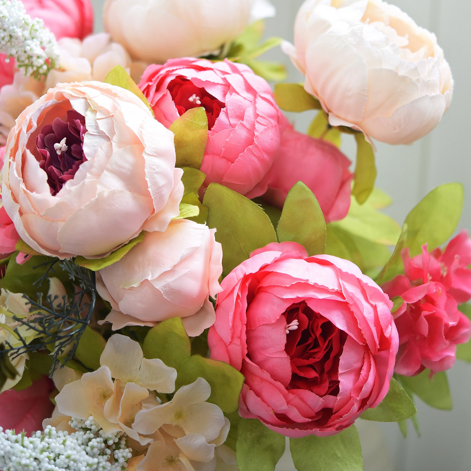 Close-up of coral and blush artificial peonies, highlighting layered silk petals and realistic bloom texture for a lifelike effect.