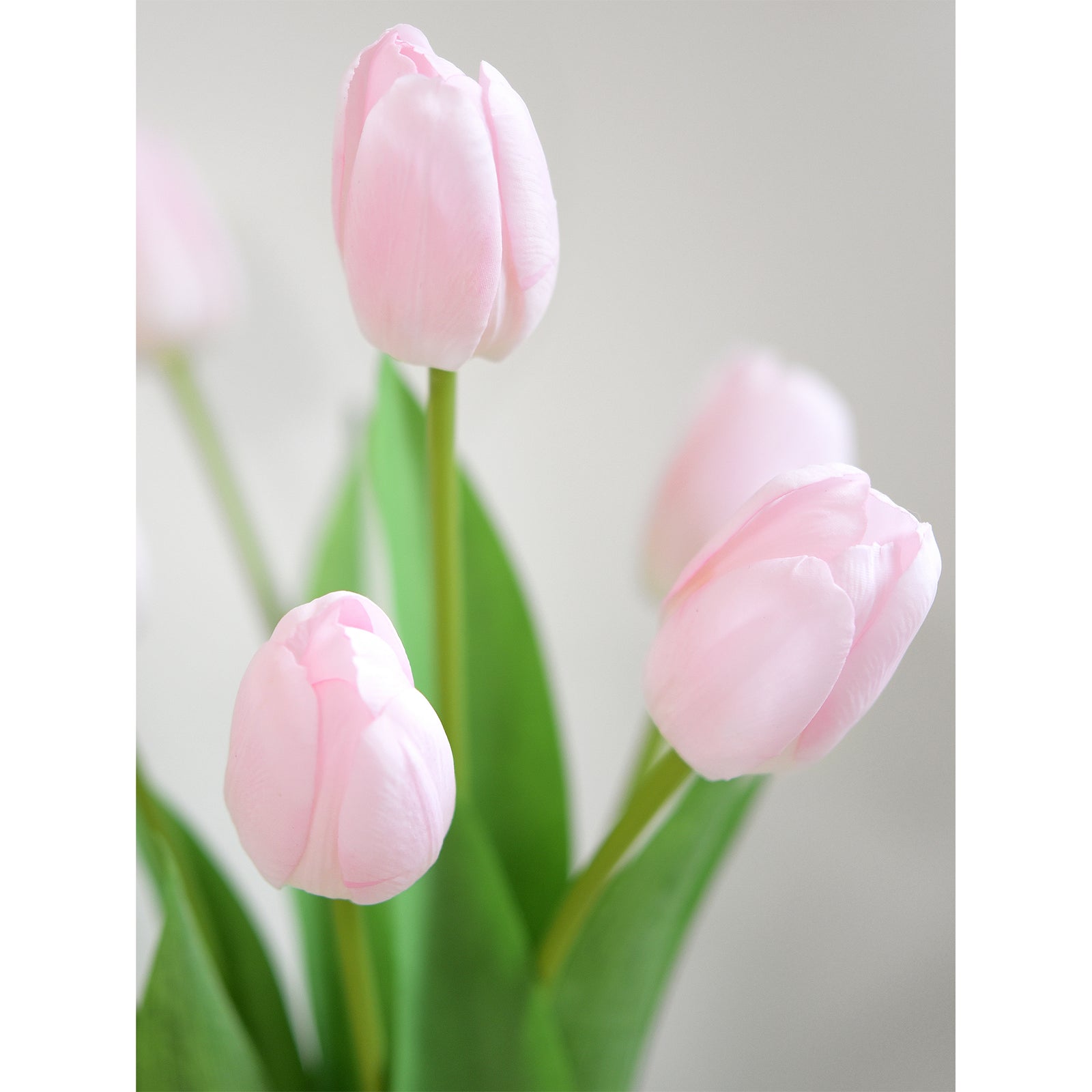 Close-up of delicate light pink artificial tulips highlighting their lifelike texture and natural appearance