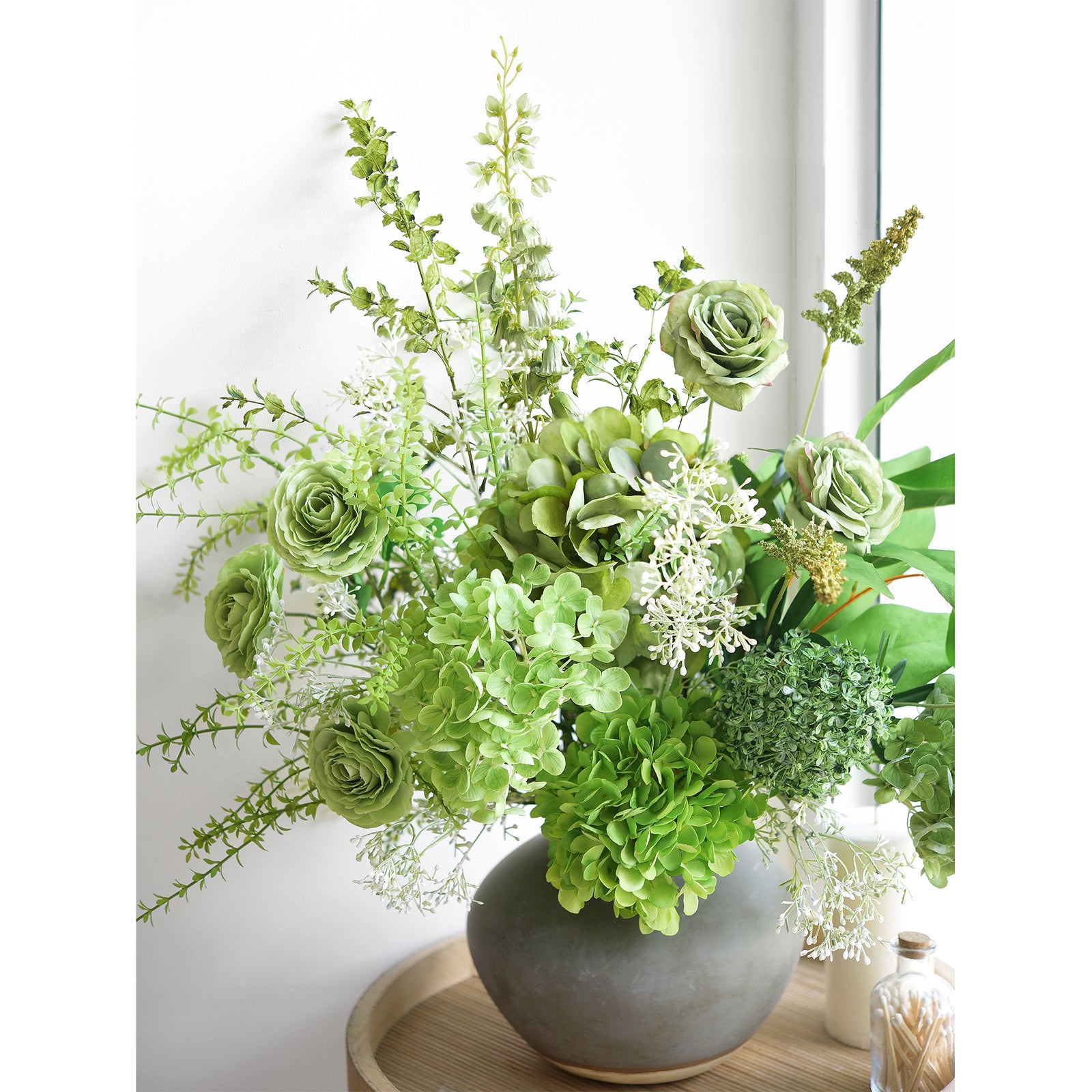 Close-up of the elegant green artificial bouquet highlighting lifelike hydrangeas, roses, and greenery.