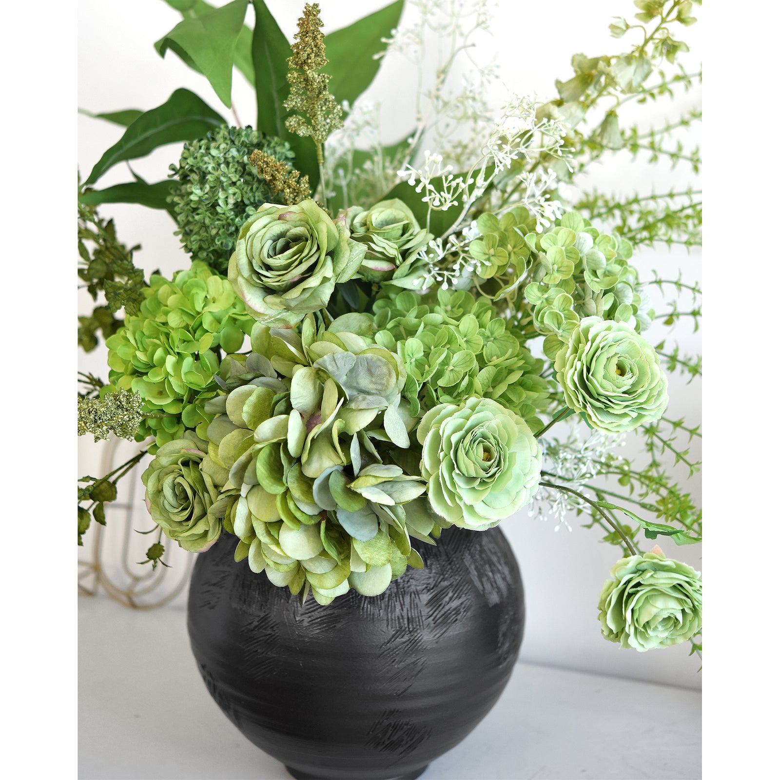 Elegant green artificial bouquet displayed in a modern setting, ideal for weddings and events.