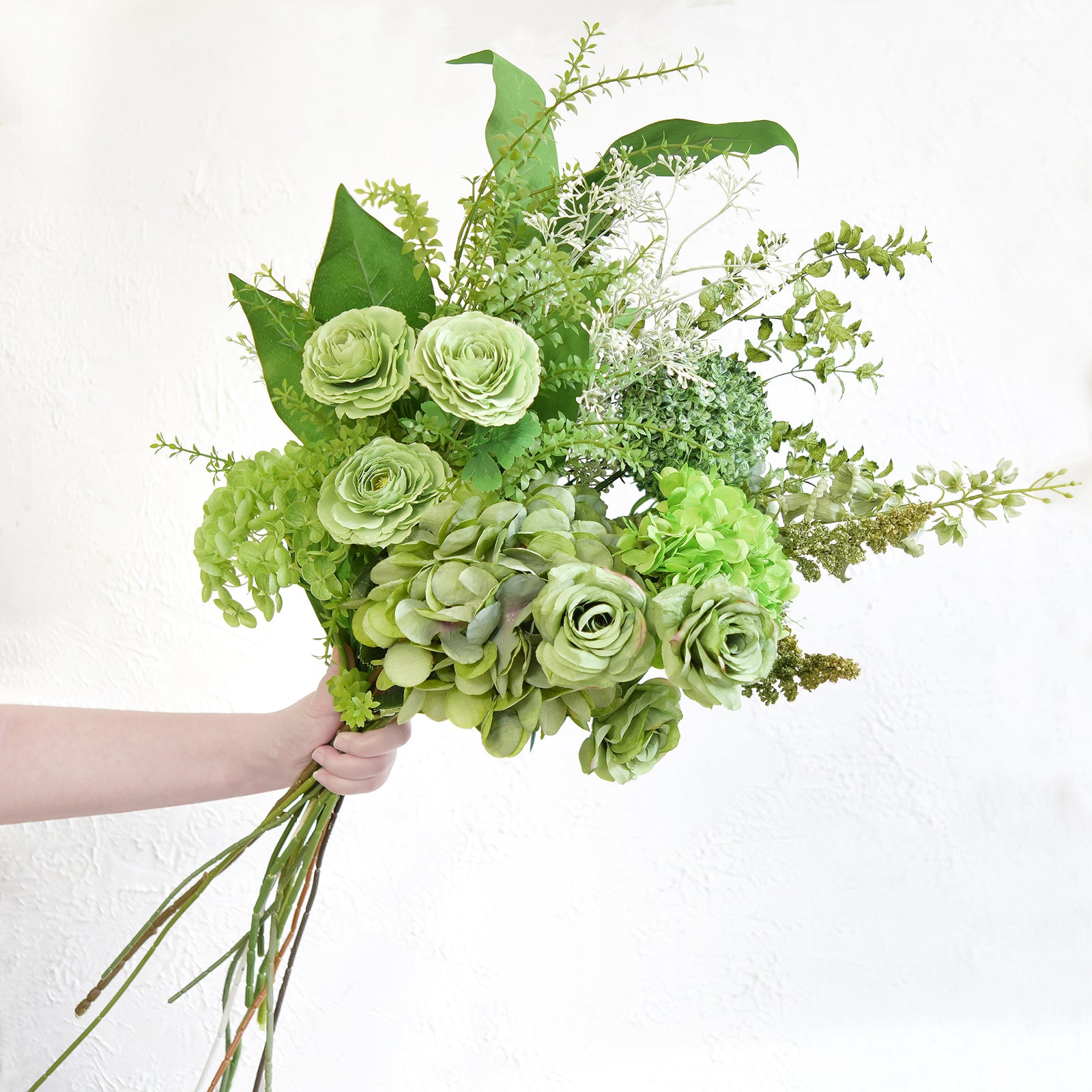 Side view of the elegant green artificial bouquet showcasing the realistic detailing of hydrangeas and roses.