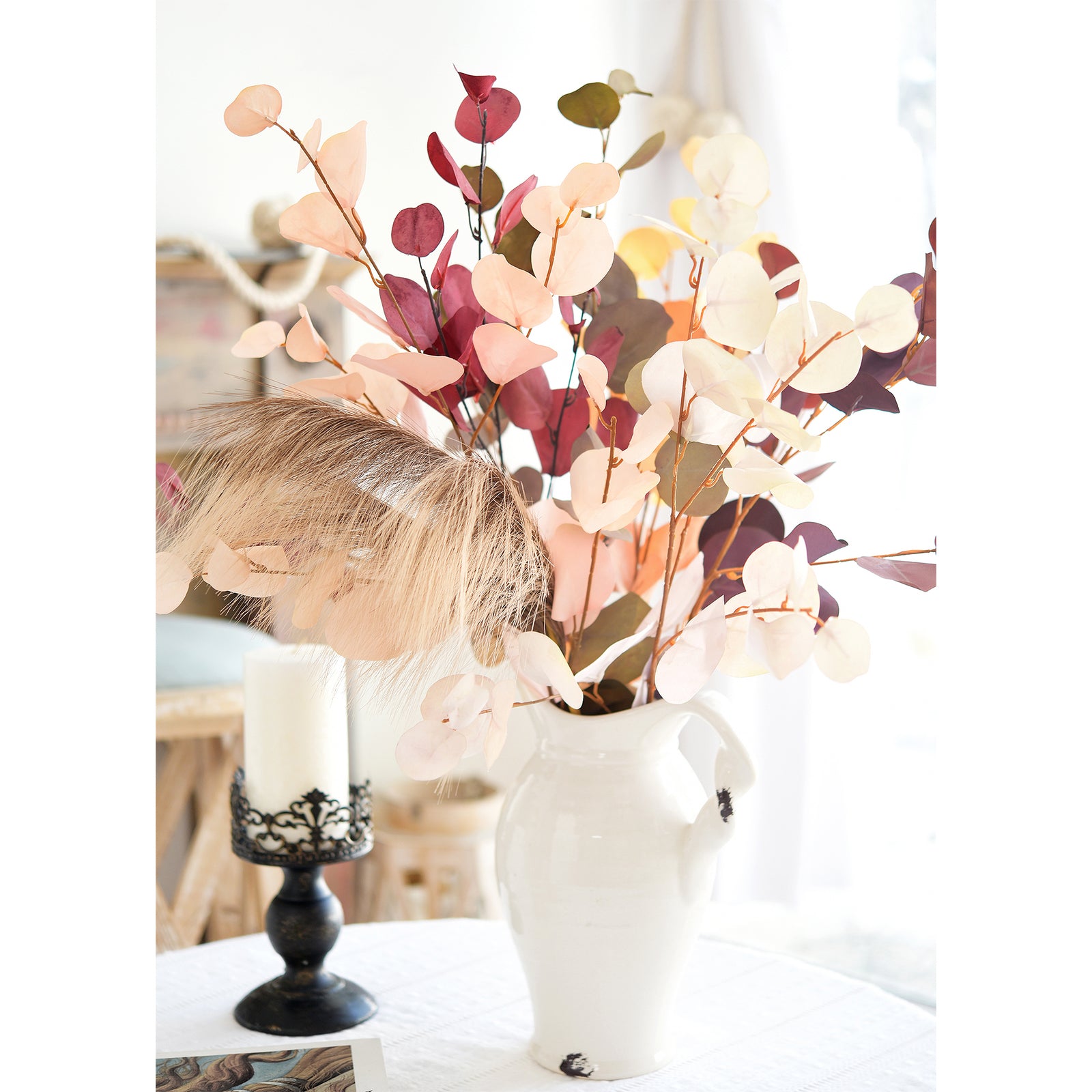 Handpicked silk eucalyptus stems in Dusky Ember, Burgundy, and Warm Taupe arranged with a candle, ideal for cozy fall decor