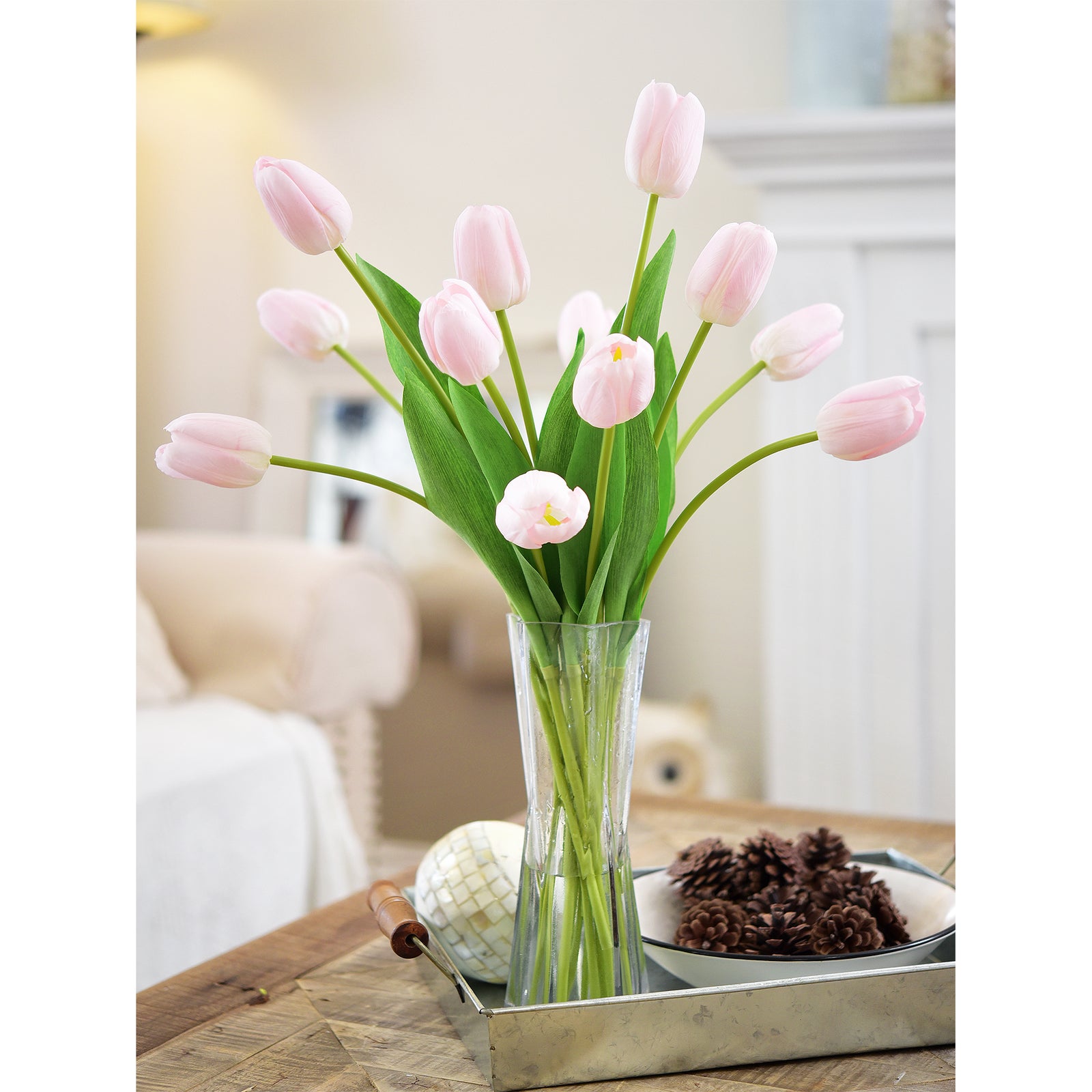 Delicate light pink artificial tulip bouquet in a clear foldable vase, styled on a cozy living room tray.