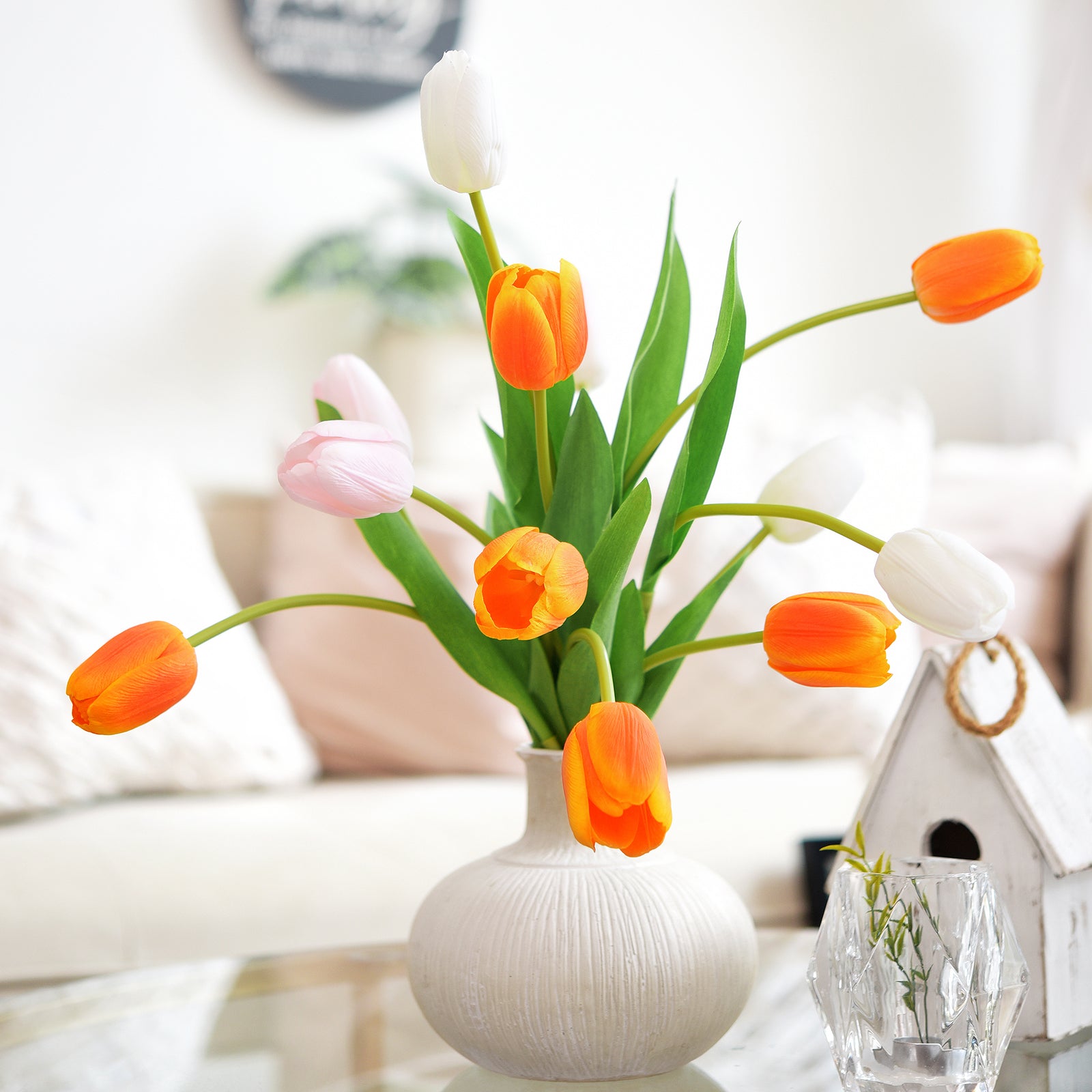 Minimalist arrangement of orange tulips in a glass vase for home office decoration.