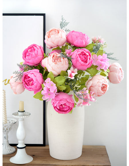 Lifelike silk peony bouquet in bright pink and blush arranged in a tall white vase, styled beside a mirror for a clean, modern look.