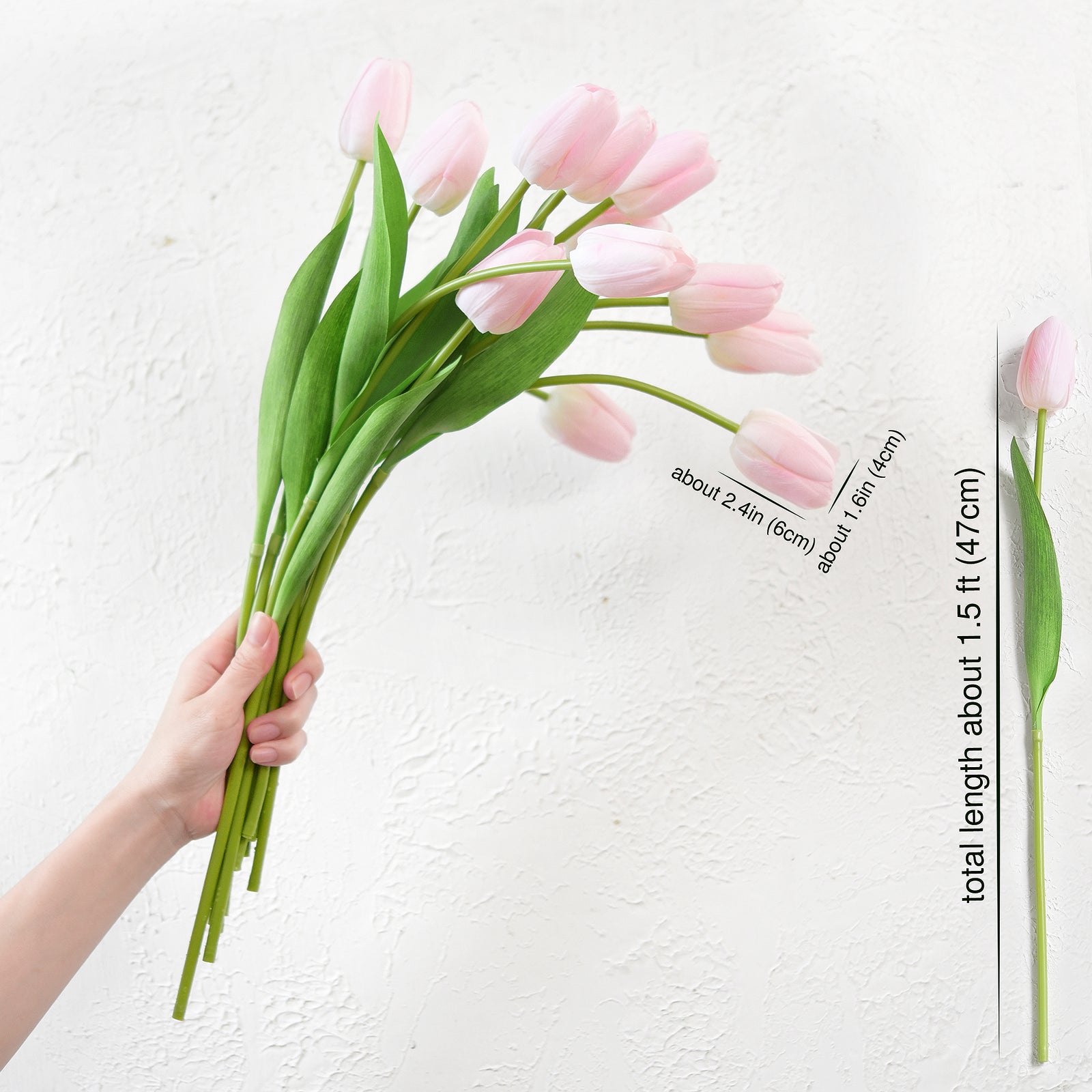 Hand holding a bouquet of long-stemmed artificial light pink tulips with measurement details for versatility in floral design.