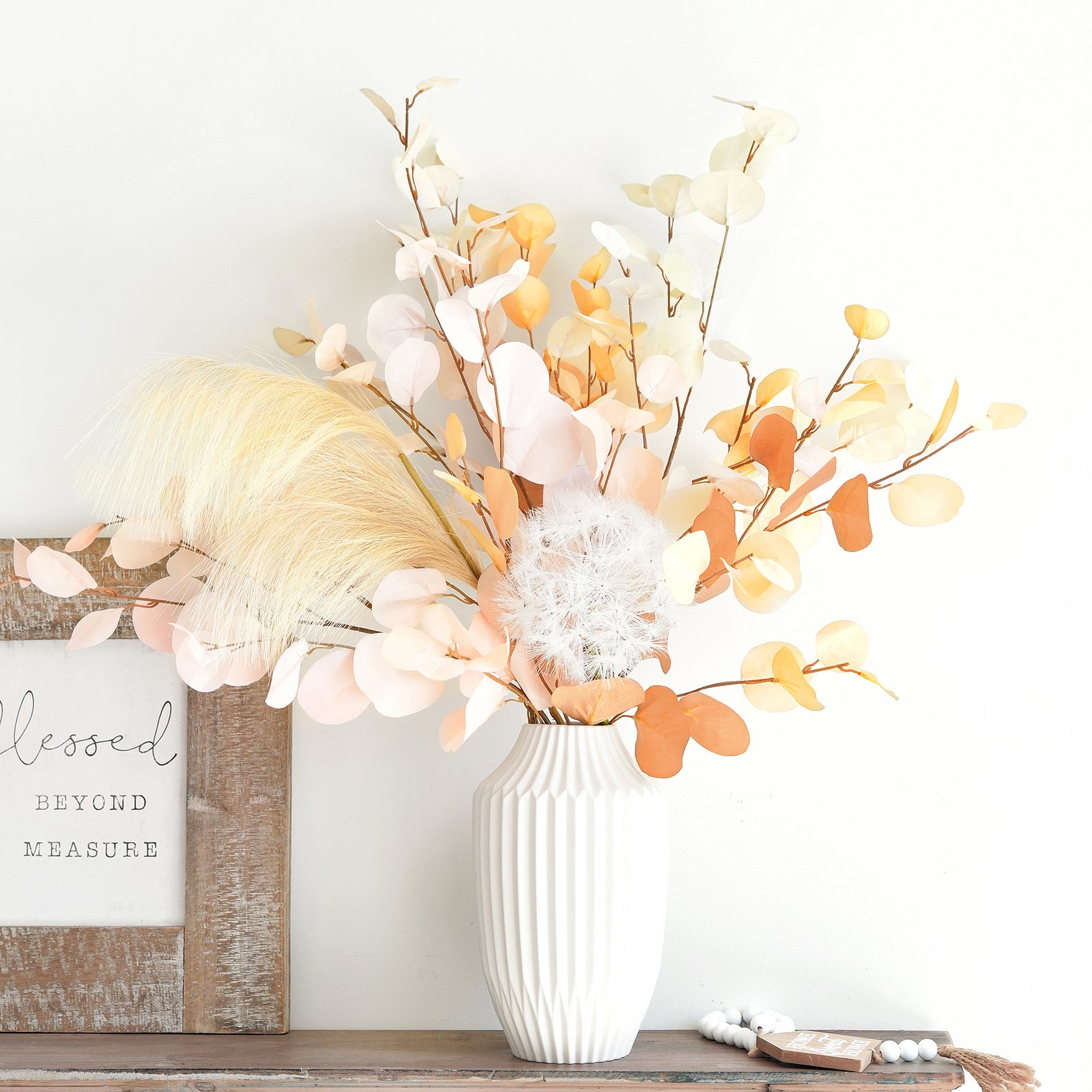 silk eucalyptus stems in Dusky Ember and Burnt Orange arranged in a white vase, perfect for adding fall elegance to home décor